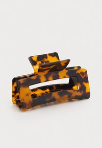 Tortoiseshell hair clip made of glossy plastic, featuring a rectangular shape with cut-out sections and raised accents on top.