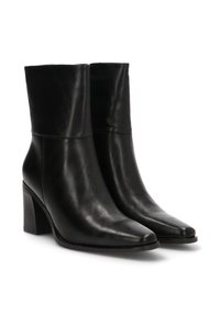 Botas de tobillo de cuero negro con un diseño elegante, punta afilada y tacón de bloque. Textura suave con detalles de costura en el cuello.