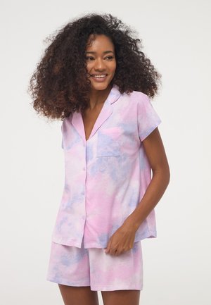 Completo pigiama a maniche corte in stampa tie-dye rosa e lavanda, con una maglietta con bottoni e taschino sul petto, abbinata a pantaloni corti.