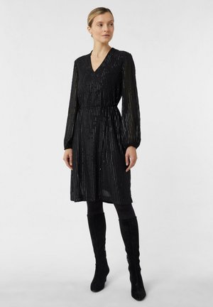 Robe noire avec manches longues élastiquées, col en V et taille cintrée. Tissu texturé avec des rayures métalliques verticales. Accessoires non inclus.