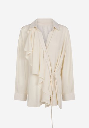 Blusa cremosa con maniche lunghe, dettaglio arricciato a sinistra, chiusura con bottoni e fiocco in vita. Tessuto morbido e testurizzato, design con colletto.