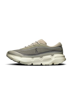 Beige og grå sportssko med mesh-overdel, tyk hvid sål og snørebånd, set fra siden mod en ensfarvet hvid baggrund.