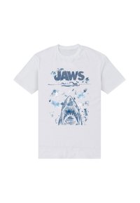 Bílé bavlněné tričko s modrým obrazcem žraloka a nápisem "JAWS" nahoře, doplněné modrými vodními stříkanci.
