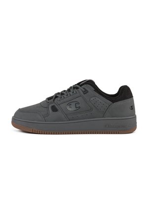 Zapatillas deportivas grises de cuero suave con un cuello texturizado negro, perforaciones en los costados y una suela de goma.