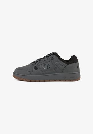 Zapatillas deportivas grises de cuero suave con un cuello texturizado negro, perforaciones en los costados y una suela de goma.