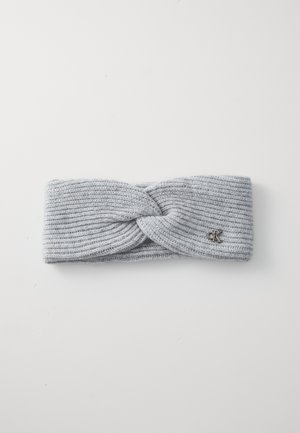 Gray knitted headband featuring a twisted design at the front and a small metal logo accent. Soft texture with ribbed detailing.