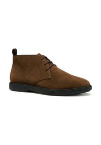 Botas de tobillo de ante marrón con punta redondeada, diseño de cordones y suela de goma negra. Presenta un pequeño tirador en el talón.