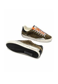 Un paio di sneakers in suede verde oliva con tallone nero, suole bianche, linguetta arancione e lacci bianchi e neri con logo.