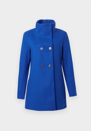 Cappotto di lana blu con un colletto alto, davanti doppiopetto e due tasche laterali. Presenta bottoni rotondi scuri e una vestibilità sartoriale.