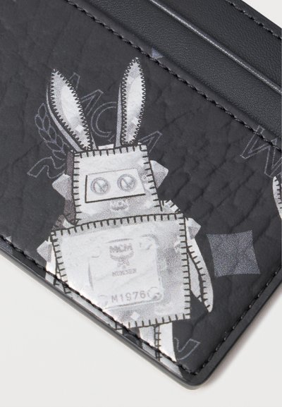 Funda de tarjetas negra con un diseño de robot con orejas de conejo, superficie texturizada, detalles gráficos en contraste y acentos de costura blanca.