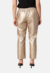 Beige, faux leren broek met een elastische tailleband, met een rechte pasvorm en een glanzende textuur.