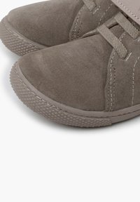 Zapatos de ante marrón con punta redondeada, suela de goma texturizada y diseño con cordones a juego. Incluye sutiles detalles de costura.
