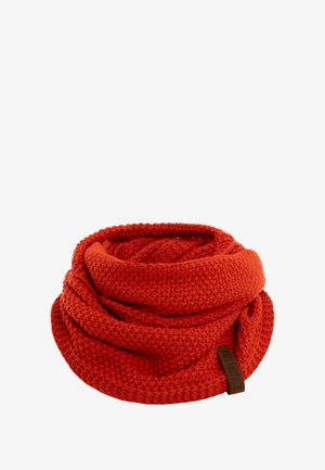 Gebreide circulaire sjaal in een levendige rode kleur. Heeft een gestructureerd patroon met een zachte, dikke weving. Bevat een klein bruin merklabel.