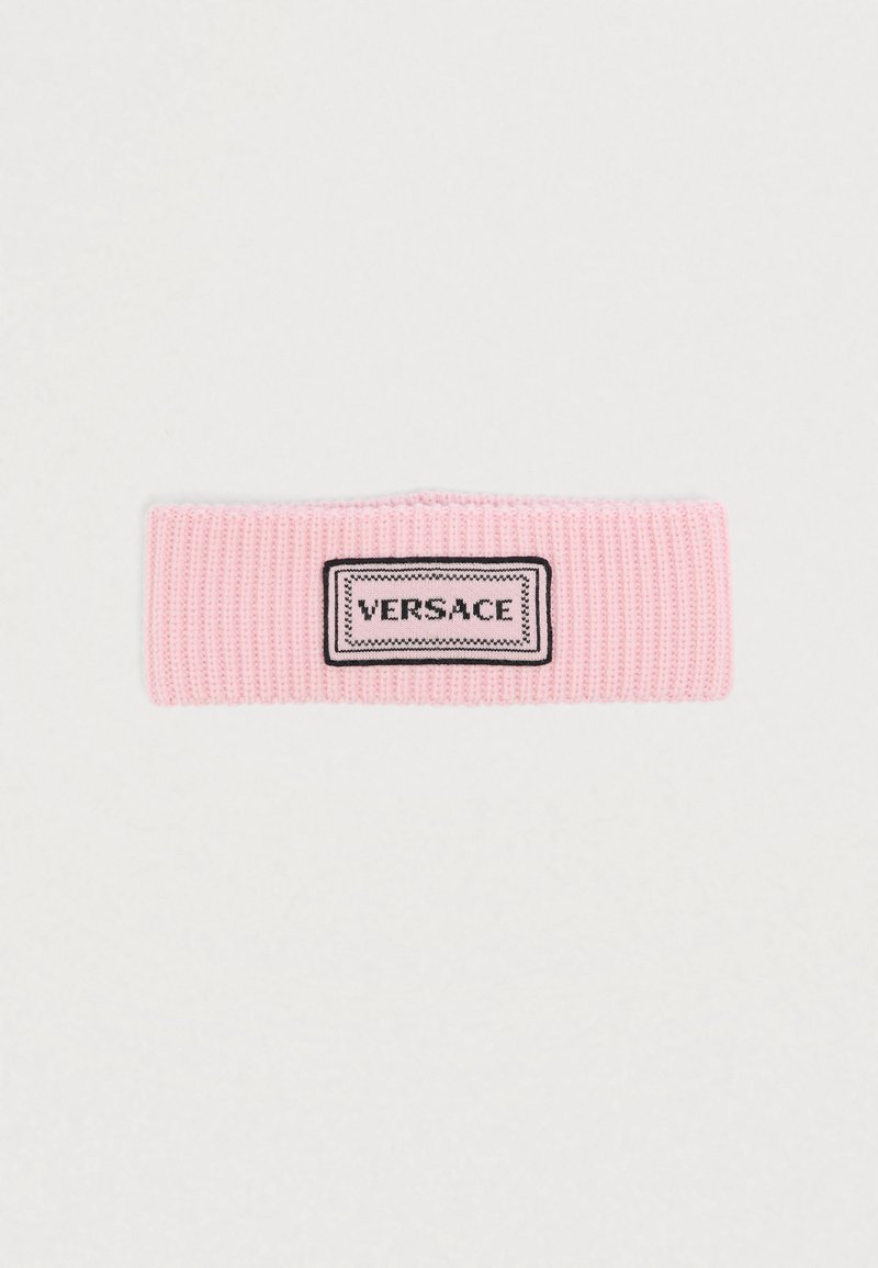 Ροζ πλεκτή κορδέλα κεφαλής με ριγωτή υφή, με ορθογώνιο μαύρο-άσπρο λογότυπο Versace στο κέντρο.