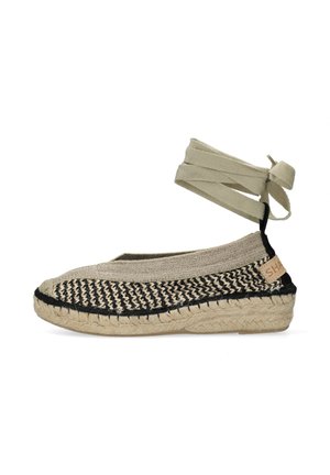 Beżowa i czarna pleciona espadryla z jutową podeszwą i beżową opaską wokół kostki zawiązaną z tyłu kokardą.