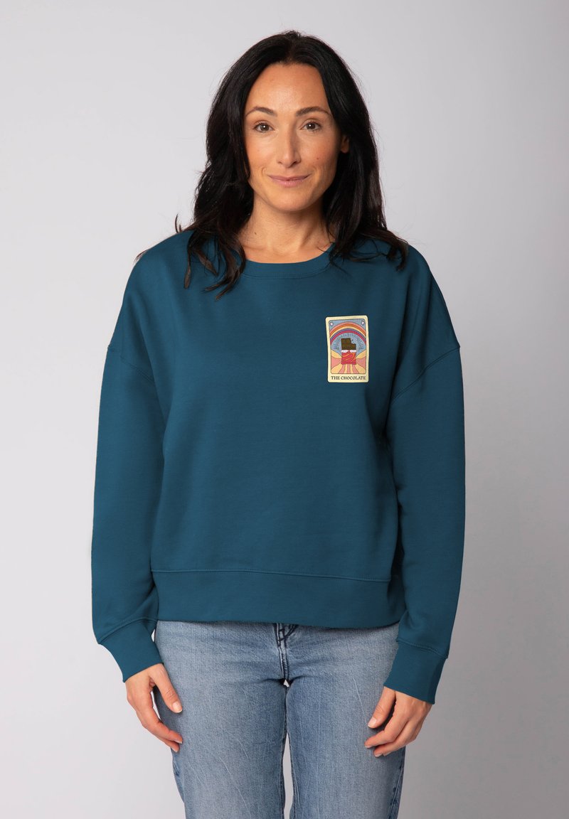 Teal sweatshirt met een ontspannen pasvorm, ribgebreide manchetten en zoom, met een rechthoekige grafische patch met een kleurrijk ontwerp op de voorkant.
