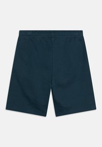 Shorts en coton bleu marine avec une taille élastique, possédant une texture lisse et une coupe droite, sans poches ni embellissements.