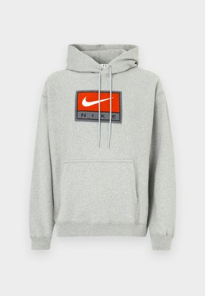 Hanorac gri cu buzunar kangaroo, având un logo Nike brodat proeminent în roșu și negru pe față și șnururi reglabile.