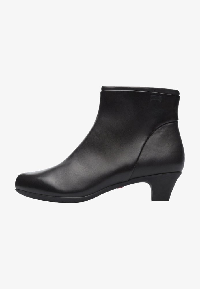 Must must täiendus musta naha põlvekõrguste saabastega, millel on sile tekstuur, ümar nina ja keskmise kõrgusega kontsad. Omab minimalistlikku disaini ja jõulist profiili.