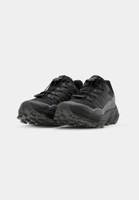 Zwarte trailrunning schoenen met een gestructureerde bovenkant, een veilig lacing systeem en een agressieve rubberen buitenzool voor grip. Inclusief reflecterende accenten.