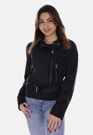 Giacca da moto nera in suede con tasche con zip, collo a pressione e dettaglio cintura; presenta una vestibilità aderente e una texture liscia.