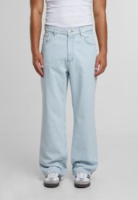 Ljusblå vida jeans med hög midja, fem fickor och dragkedjestängning, tillverkade av denim med minimala sömnadsdetaljer.