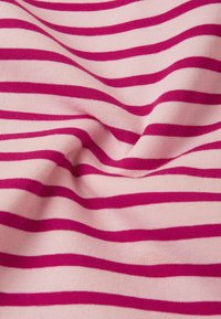 Tkanina bawełniana w poziome paski; jasnoróżowe tło z wyraźnymi fioletowymi liniami. Miękka tekstura z gładkim wykończeniem.