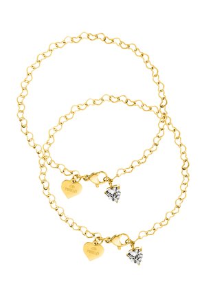 Zwei goldene Kettenarmbänder mit jeweils einem herzförmigen PURELEI-Anhänger und einem klaren Kristallherz-Anhänger, auf weißem Hintergrund ausgelegt.