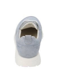 Zapatilla de gamuza azul claro con forma redondeada, textura suave, suela de goma blanca y un pequeño tirador en el talón.