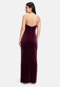 Robe maxi en velours bordeaux avec de fines bretelles réglables et un dos nu. Design ajusté avec une texture lisse et des détails de couture.