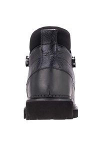 Botín negro de cuero con superficie texturizada, cuello acolchado y suela plana de goma. Presenta un tacón redondo y detalles de costura sutiles.