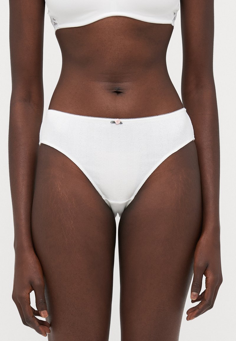 Witte katoenen slips met een gestructureerd patroon, elastische tailleband en een klein roze strikje in het midden vooraan. Mid-rise snit en een gladde afwerking.