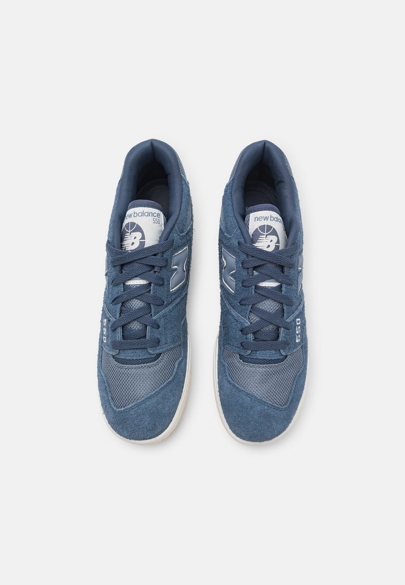 Sneaker blu in mesh e suede con colletto imbottito, presentano un logo bianco, lacci piatti e una suola in gomma di colore chiaro.
