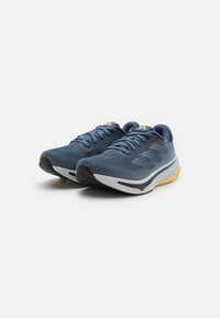 Plave mrežaste atletske tenisice sivi naglasci, s udobnim bijelim midsole-om i crnim potplatom. Imaju sustav vezanja i detalje s logotipom.