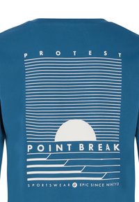Plava majica s grafičkim dizajnom koji uključuje horizontalne bijele linije i motiv sunca. Tekst sadrži "PROTEST" i "POINT BREAK" u podebljanim slovima.