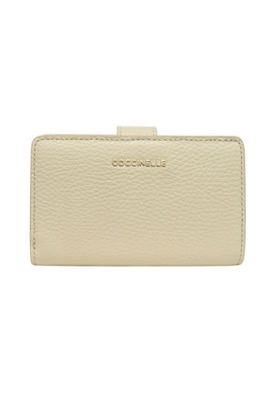 Portafoglio beige in pelle lavorata con bordi cuciti e chiusura a linguetta, caratterizzato dal logo "COCCINELLE" in lettere dorate al centro della parte anteriore.