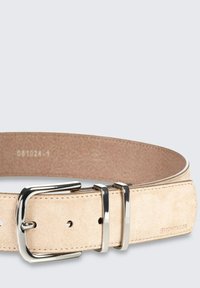 Beige suède riem met een glanzende zilveren rechthoekige gesp en dubbele pinnen. Voorzien van stiksels langs de randen en gaatjes voor verstelbaarheid.