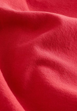 Red textured fabric with a smooth but slightly raised weave, featuring soft, draped folds that create a wave-like appearance.