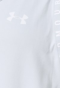 Maglietta atletica azzurro chiaro con una superficie liscia, con logo Under Armour bianco e scritte bianche sul lato.