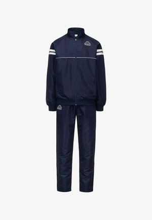 Tuta navy realizzato in un tessuto liscio e lucido; presenta una giacca con zip e strisce bianche e pantaloni coordinati, entrambi con elementi che riportano il logo.