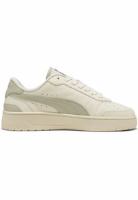 Adidași din piele crem cu vârful rotunjit, detalii perforate și un accent verde deschis pe călcâi. Talpă plată cu textură.