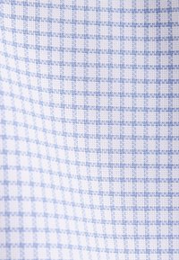 Tissu textile à carreaux bleu clair et blanc avec un motif tissé texturé.