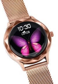 Montre intelligente en or rose avec un écran rond et réfléchissant affichant un papillon rose. Dispose d'un bracelet en métal maillé et d'un boîtier texturé.