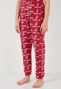 Röda pyjamasbyxor med elastisk midja, prydda med ett upprepande mönster av tecknat karaktärer och texten "KÄRA KÄRLEK" i vitt på en rosa bakgrund.