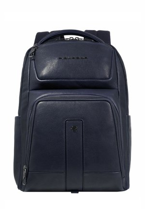 Mochila de cuero azul marino con textura suave, bolsillo frontal con cremallera y correas acolchadas. Presenta un asa superior y un acento de logo en el panel frontal.