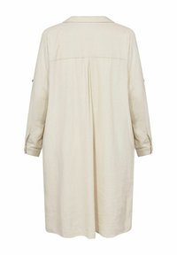 Beige linane särgkleit kraega, pikkade varrukatega ja keskel voldiga seljal. Nööbiga mansetid ja laiform. 