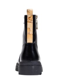 Bota de cuero negro con suela gruesa, tirador beige con un diseño de mapa vintage y una cremallera dorada en el lateral.