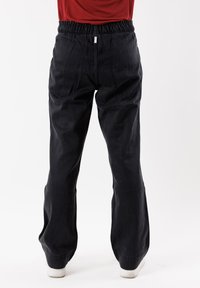 Pantaloni neri, larghi e con elastiche in vita, con un design a gamba dritta e una texture liscia, mostrati da dietro.