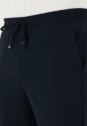 Námornícke modré športové nohavice s elastickým pásom, nastaviteľnou šnúrkou a bočnými vreckami, vyrobené z mäkkého, ľahkého materiálu.