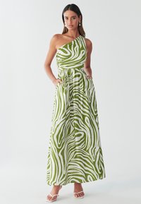 Maxikleid mit einem Träger in grün-weißen Zebrastreifen. Hergestellt aus leichtem Stoff mit gerafftem Oberteil und Seitentaschen.